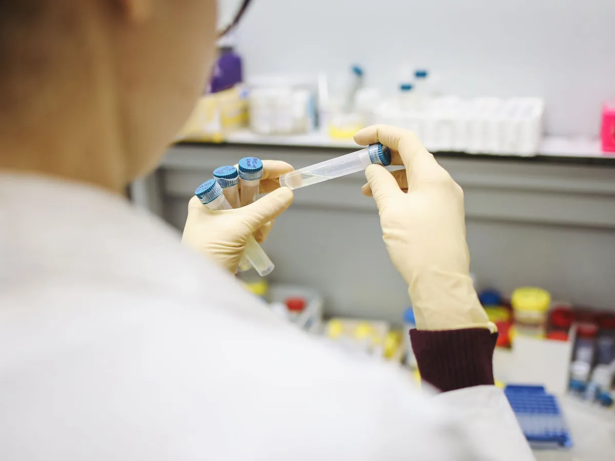 Laboratory technician handling dairy quality samples in test tubes