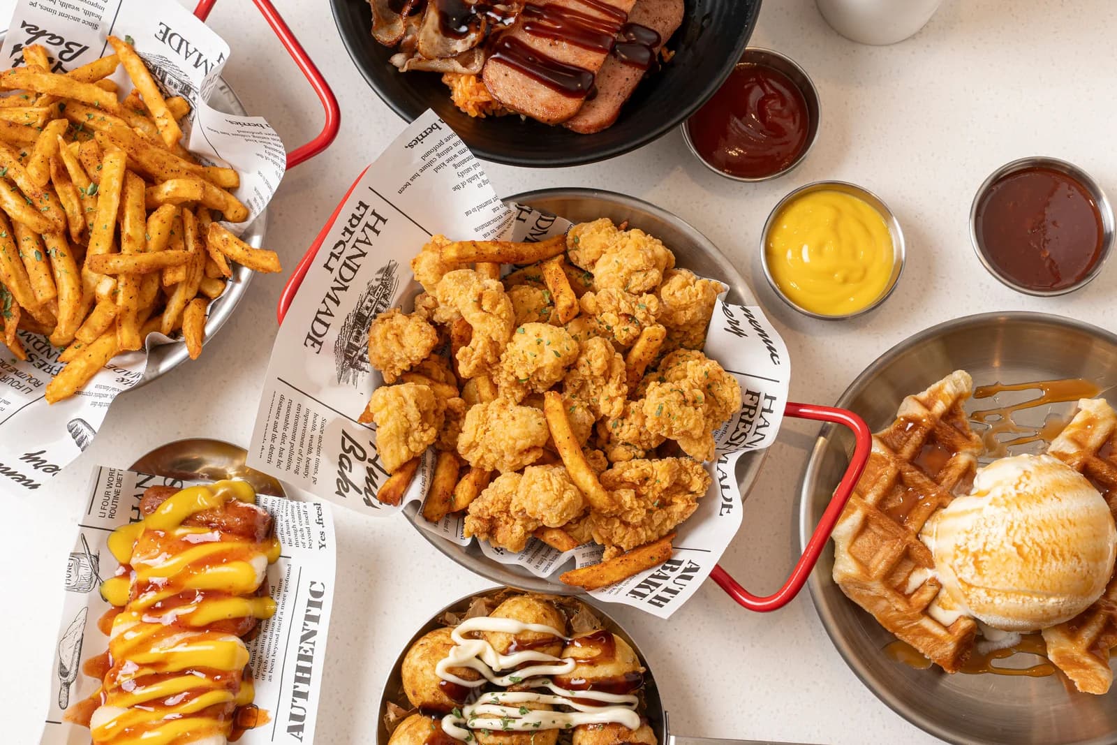 Assorted fried chicken, fries and prepared foods served with sauces