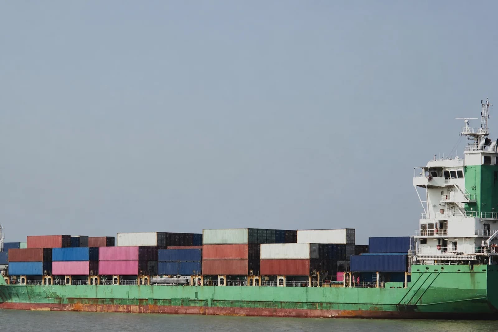 Unbranded container ship carrying cargo across open water