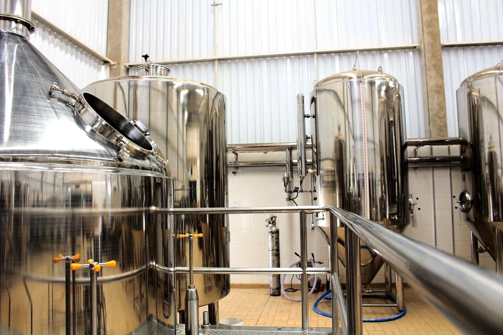 Stainless-steel tanks and pipework inside an industrial processing plant