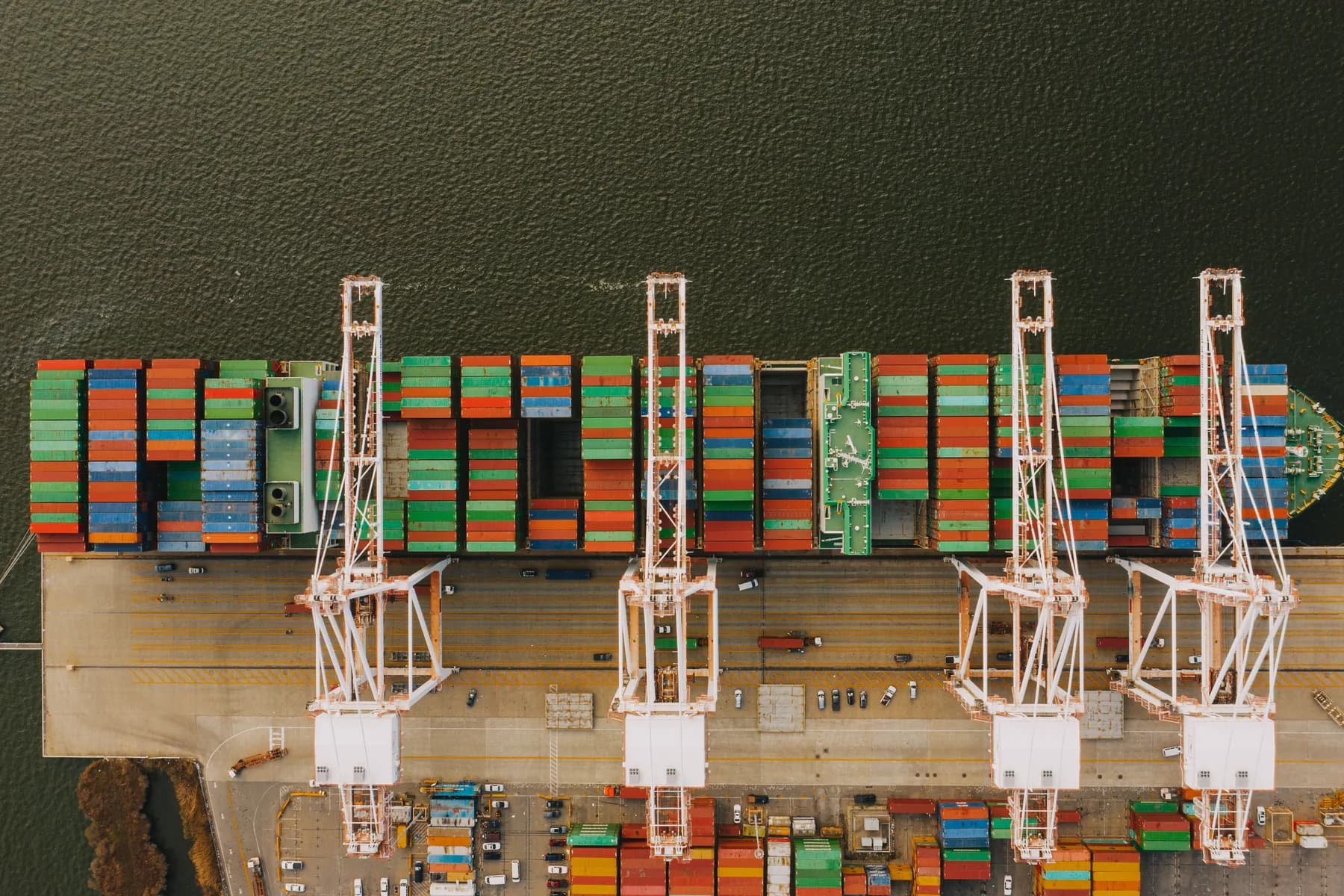 Aerial view of a container ship and port cranes representing global sourcing routes