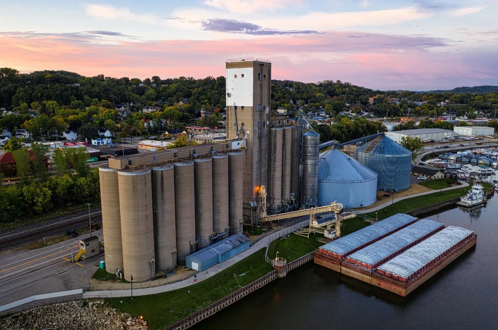 Riverside grain silos and loading facilities viewed from above at sunset