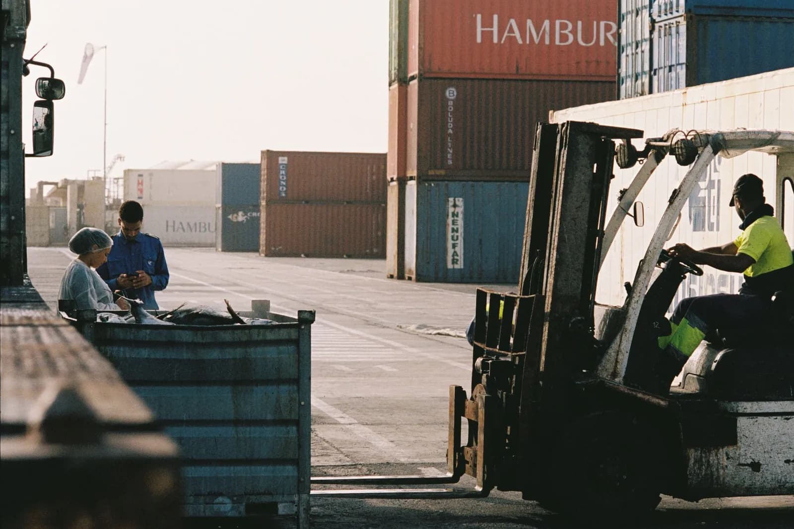 Forklift and operations staff working at a container transshipment terminal